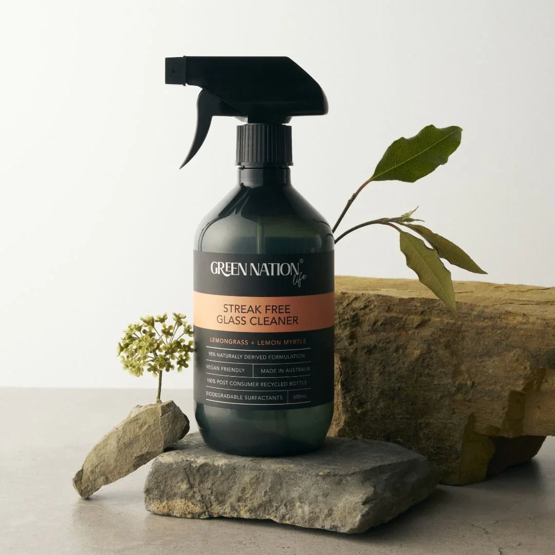 Green Nation Life streak free glass cleaner bottle on stone with leaves and small flower