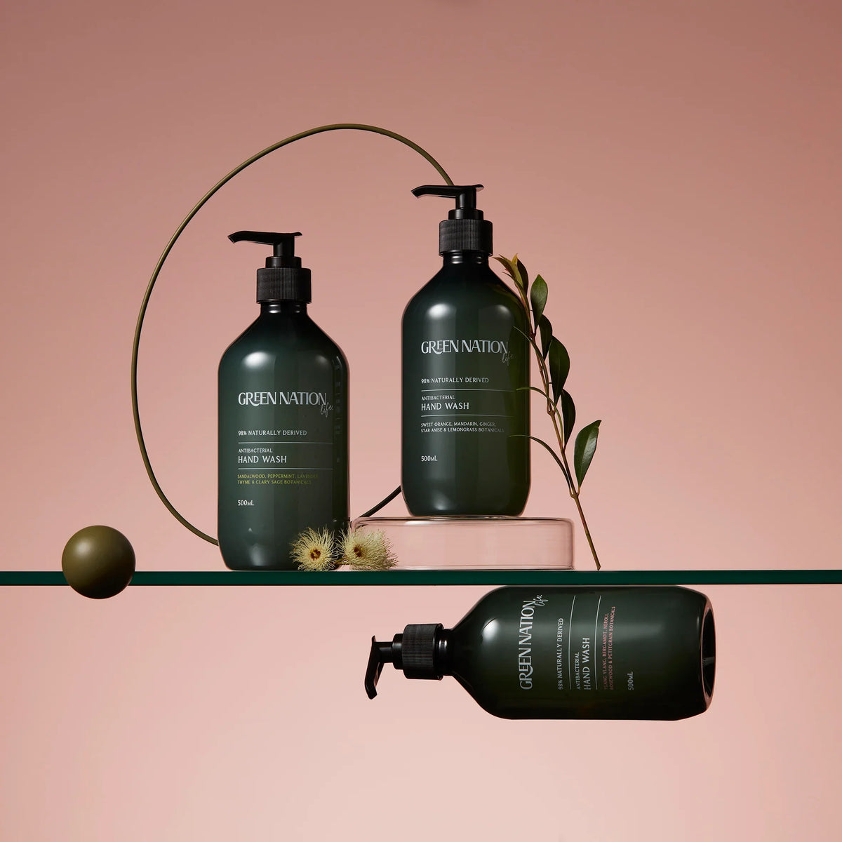 Green Nation Life antibacterial hand wash bottles on glass shelf with botanical accents