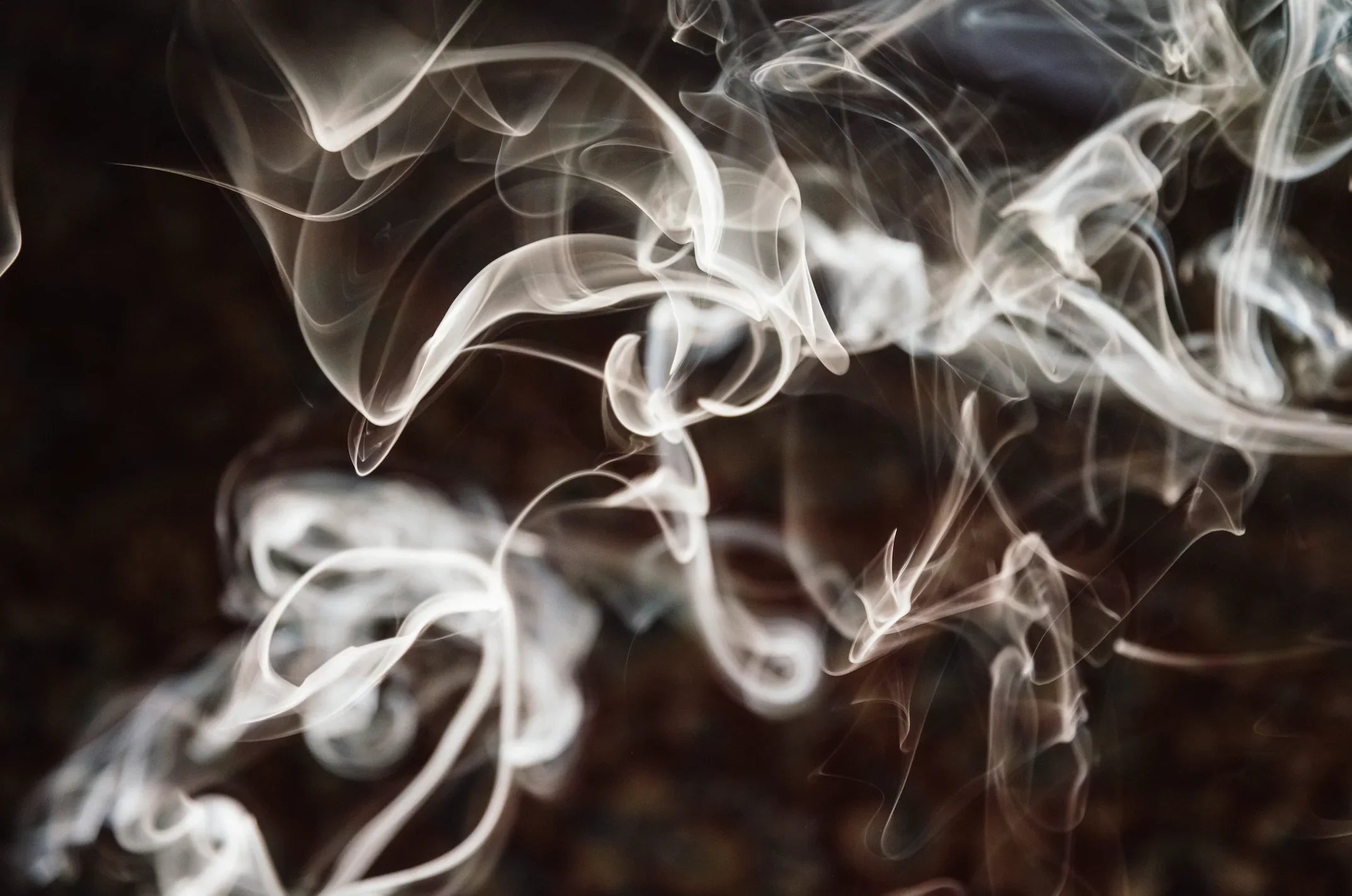 White smoke swirling on a dark background, abstract smoke pattern texture