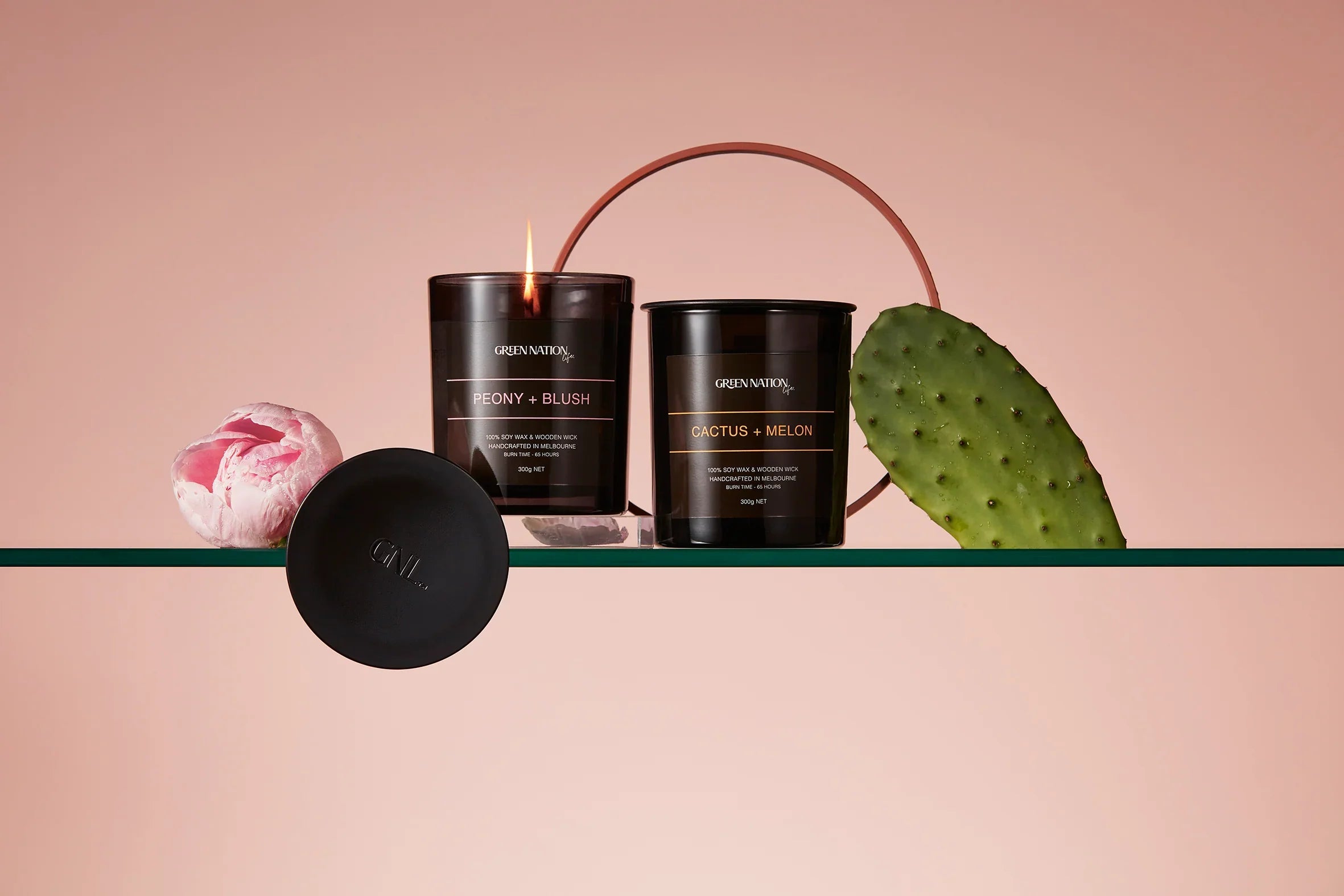 Green Nation Life candles Peony Blush and Cactus Melon with flower and cactus on a glass shelf