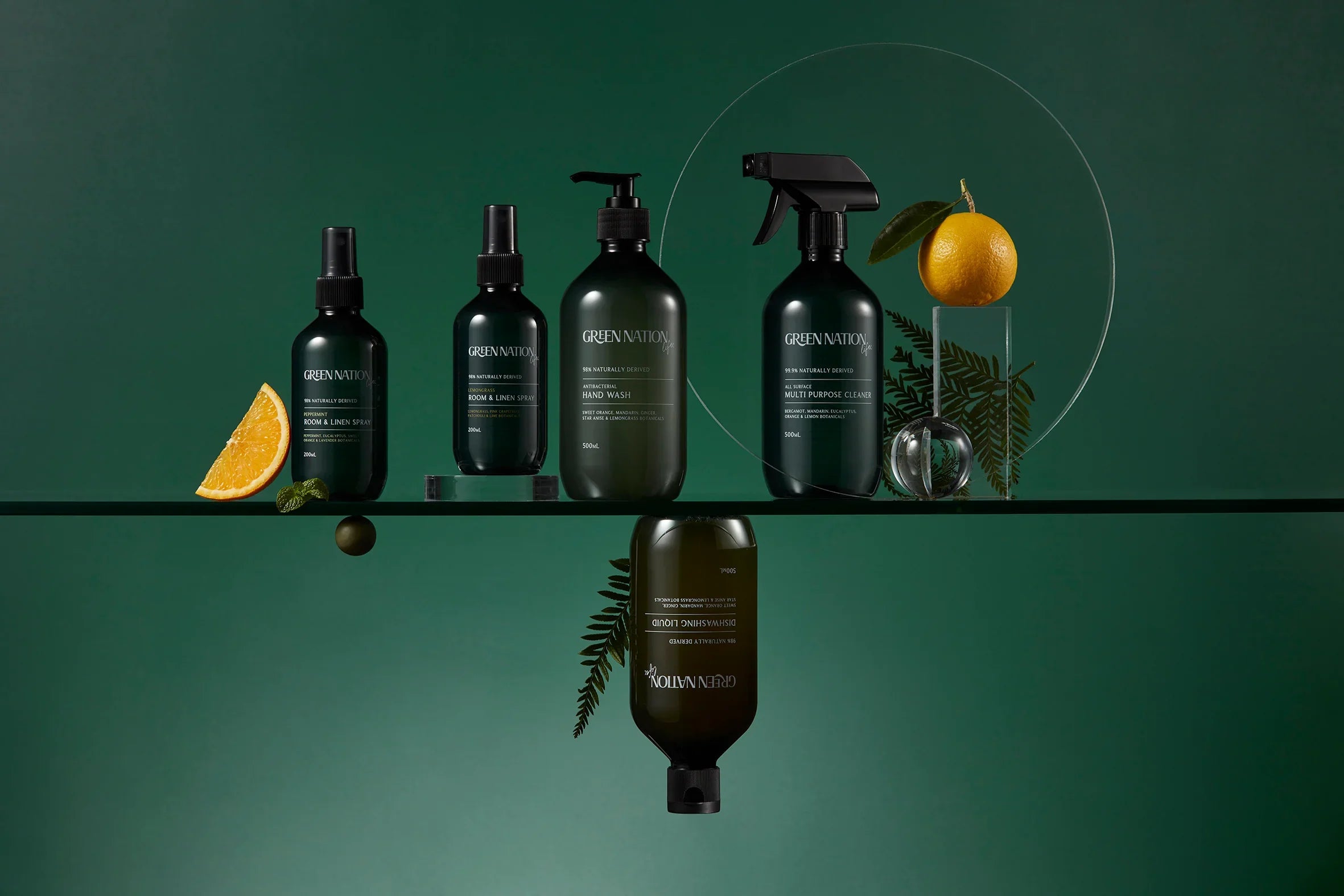 Green Nation natural cleaning and hand wash products on glass shelf with orange and green accents