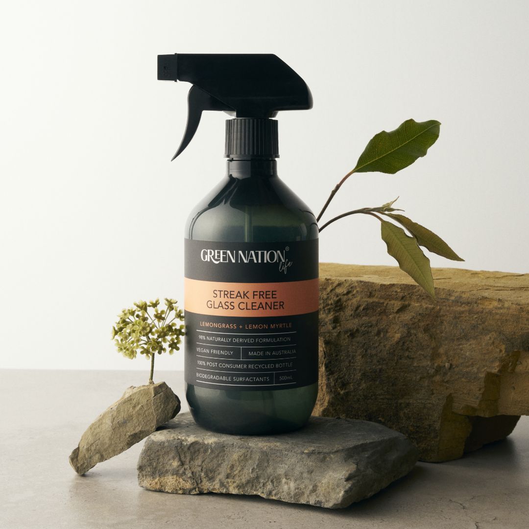 Green Nation Life streak free glass cleaner bottle on stone with leaves and small flower