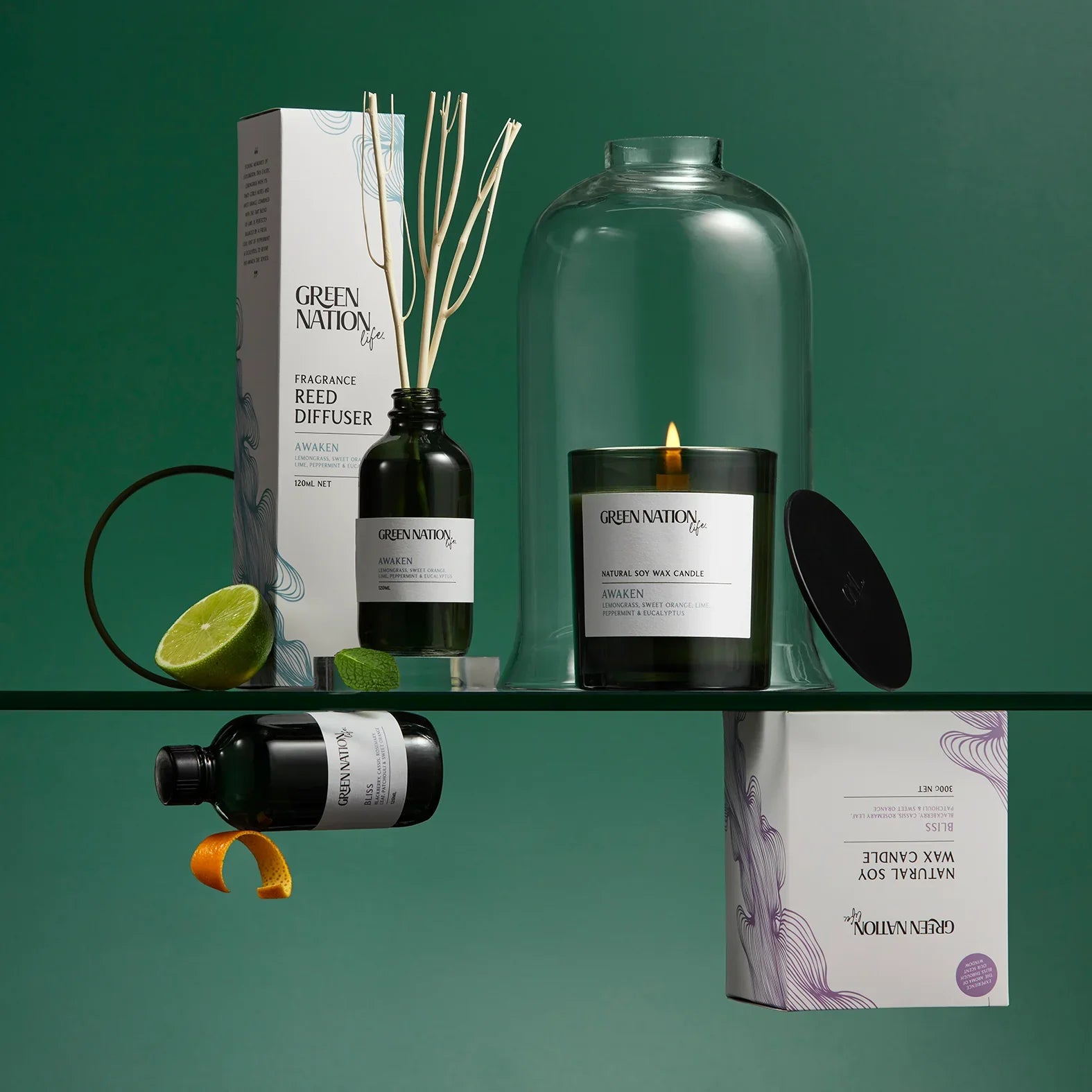 Green Nation Life aromatherapy reed diffuser and soy wax candle with lime and orange on green background