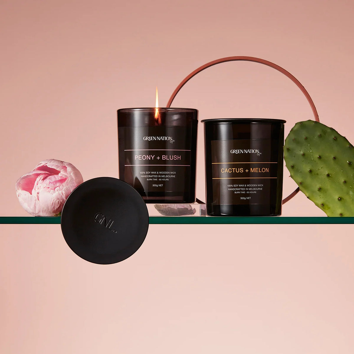 Green Nation Life black soy candles Peony Blush and Cactus Melon on glass shelf with cactus and peony