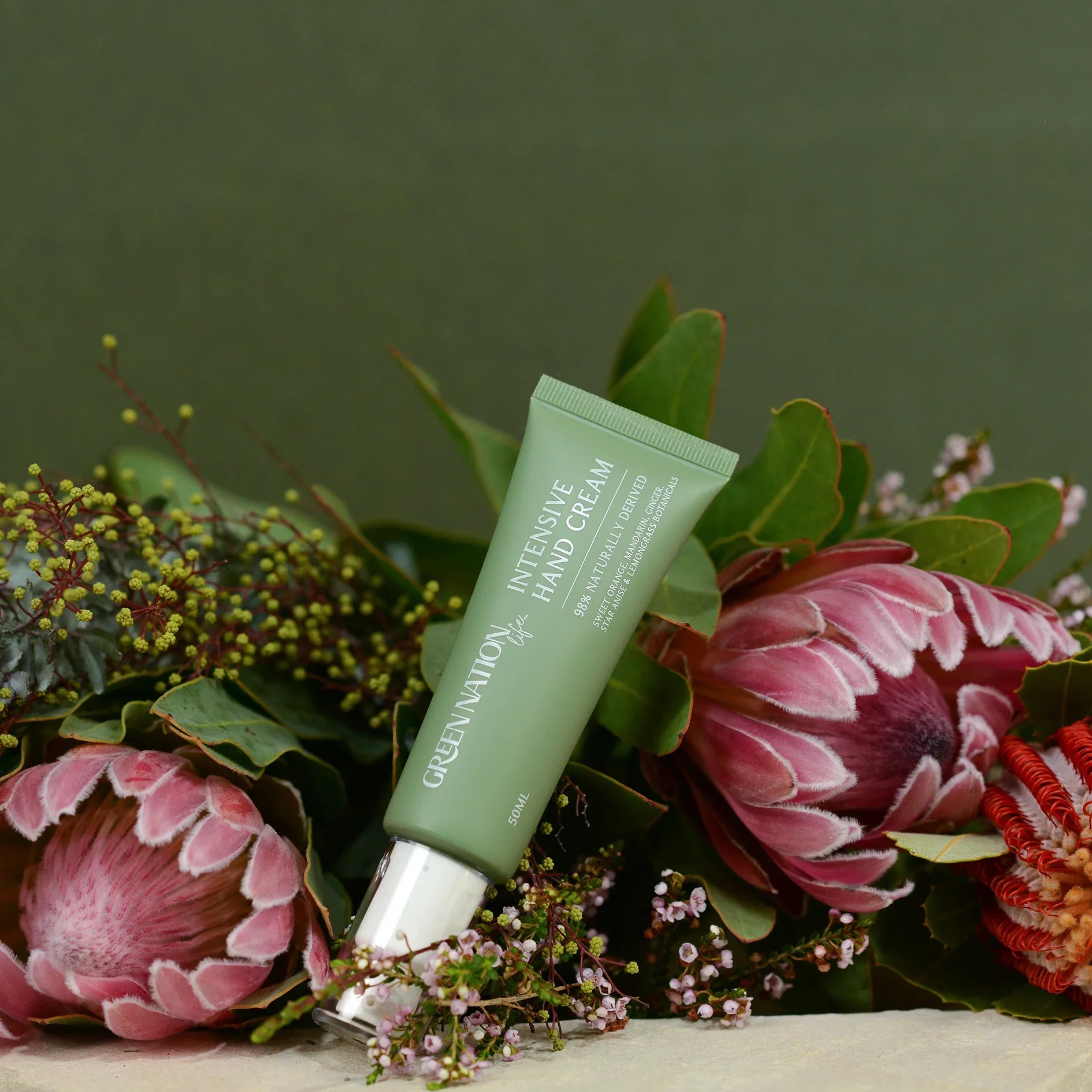 Green Nation Life Intensive Hand Cream tube on flowers with green background