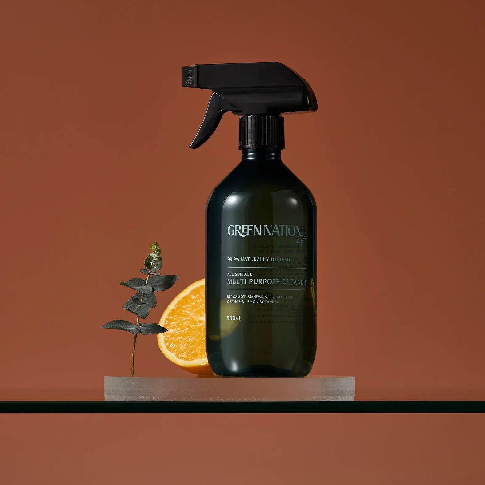 Green Nation multipurpose cleaner spray with orange slice and eucalyptus on brown background